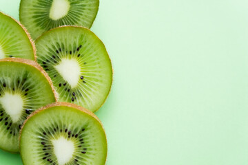 top view of sliced fresh kiwi on green. - obrazy, fototapety, plakaty