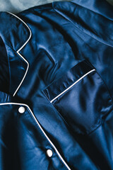 luxurious navy blue silk or satin tailored pyjama detail, fabric close-up with soft wrinkles