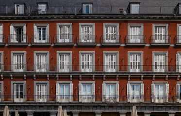 Facade of red building with balconies. Madrid, Spain