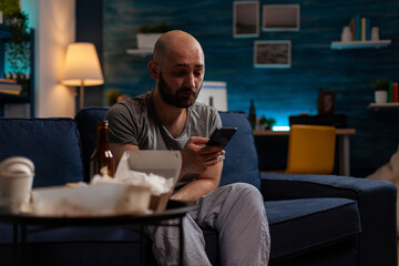 Sad anxious adult with suicidal thoughts using smartphone app to chat on social media. Depressed young man dealing with chronic mental illness and using mobile phone technology.