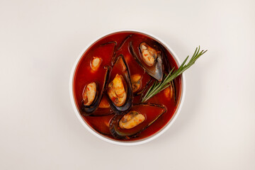 Tomato soup with mussels on light background, top view