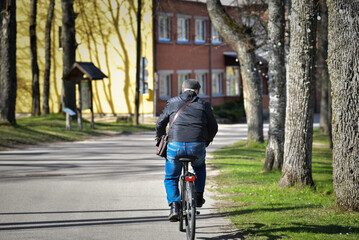 A man rides a bike on an asphalt road