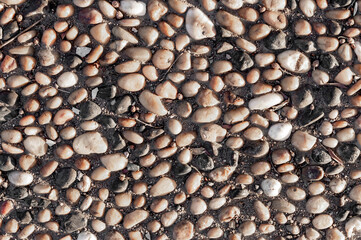 Background of small stones on the road. Rough surface of small pebble stone.