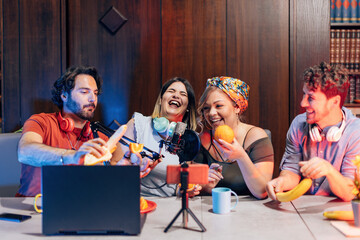 group of young influencer people having fun and playing with fruit while vlogging video together - obrazy, fototapety, plakaty