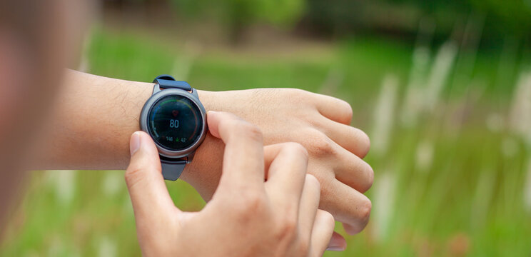 Smart watch. Smart watch on the hands of an outdoor man Man's hand touching watch . Close-up shot of using a digital watch to measure heart rate outdoors.