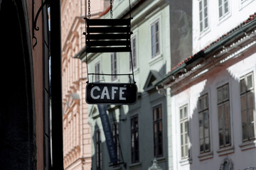 Signboard of a cafe on a wooden board in the historical center of a European city