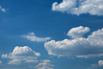 Naklejka na ściany i meble Rare cumulus clouds against a clear blue sky. High quality photo