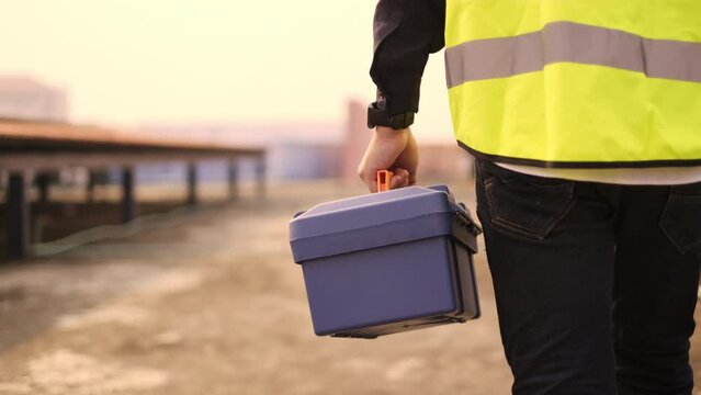 4K slow motion. Technician worker holding tool box walking on site work.   Maintenance or repair job.