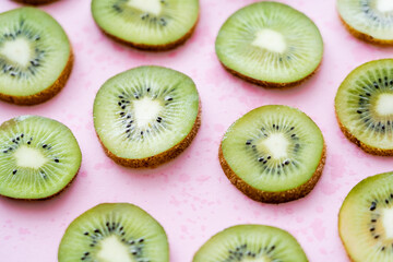 close up view of sliced fresh kiwi on pink.