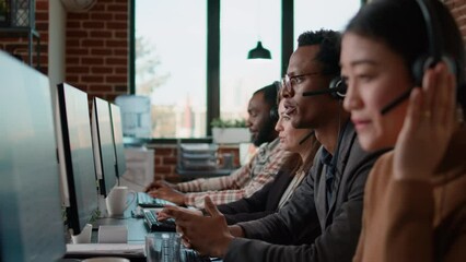 Helpline agents talking to clients on headset at call center job, using computer to have remote conversation. People working at customer service care helping with telemarketing communication. - Powered by Adobe