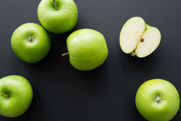 top view of juicy and green apples on black.
