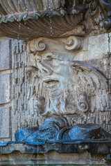 Ancient sculpture of funny, tricky and joyful dickens at fountains in historical downtown of Dresden, Germany, details, closeup. Concept of art and historical heritage.