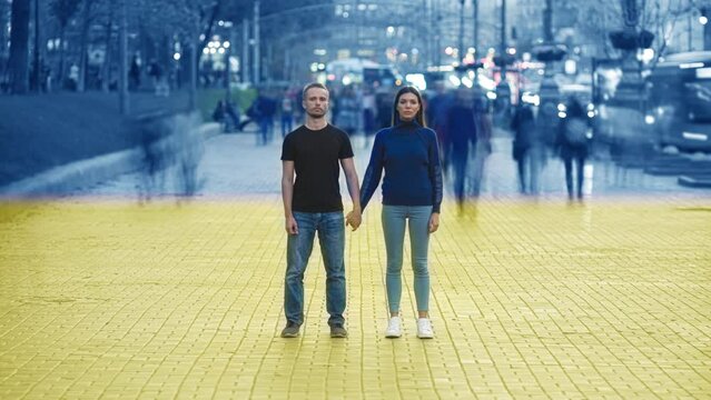 The man and woman standing on the street on ukrainian flag background. timelapse