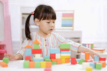  young girl playing creative toy blocks for homeschooling