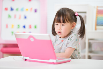 young girl using laptop for online learning during lockdown time