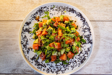 salad with salmon avocado arugula and black sesame