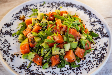 salad with salmon avocado arugula and black sesame
