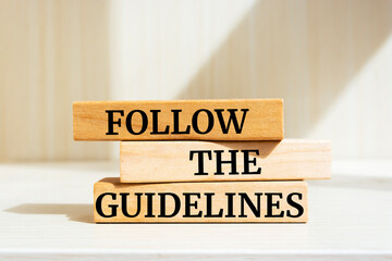 Wooden blocks with words 'Follow the Guidelines'. Business concept