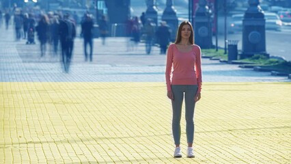 The woman stands on crowdy street on the ukrainian flag background. time lapse