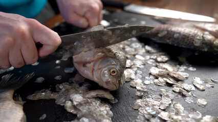 Fish is getting cut with a knife