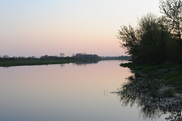 Peaceful river and trees with sky reflecting in spring in Europe