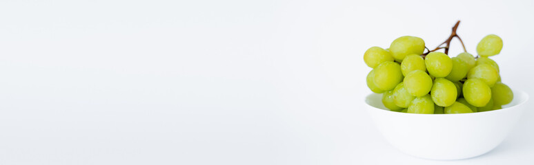 fresh and green grapes in bowl on white, banner.