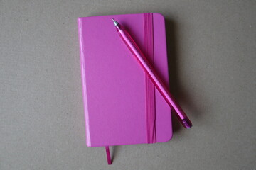 pink notebook and pen