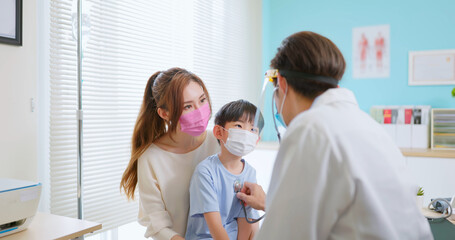 pediatrician examining sick boy