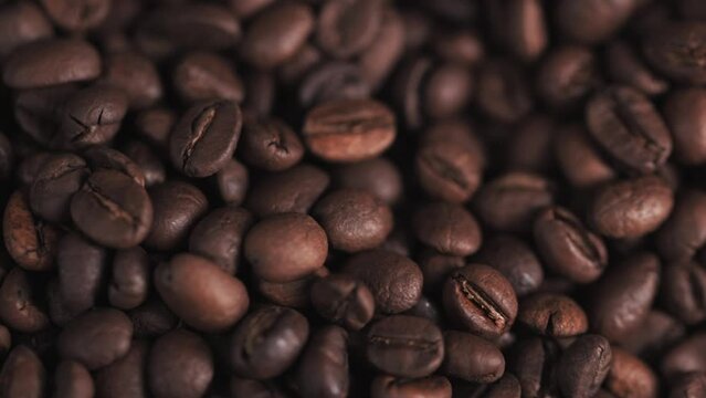 Coffee beans on, camera moves , close up.Freshly roasted coffee on canvas.Coffee beans in the bag.A handful of coffee beans on a brown canvas.