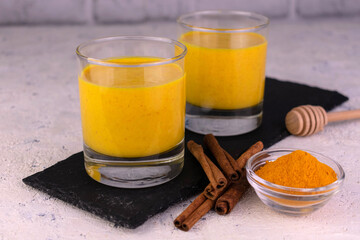 Latte with turmeric.Golden milk with cinnamon served on a slate board.Healthy vegan drink.
