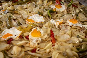 Lots of potatoes with onions and eggs in a big pan.Typical dish of the Spanish fairs.