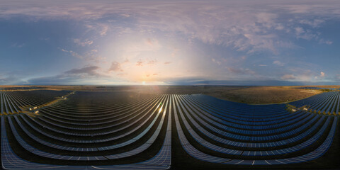 Aerial panorama over solar panels power plant. Photovoltaic solar panels at sunrise sunset in...