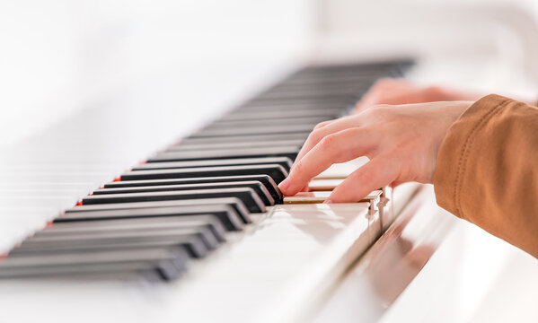 Selective focus to kid fingers and piano key to play the piano. There are musical instrument for concert or learning music.