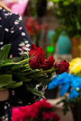 Fototapeta na wymiar Bouquet of red roses. Gift idea for valentine's day. Florist woman holding a fresh bouquet.