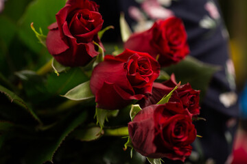 Bouquet of red roses. Gift idea for valentine's day. Florist woman holding a fresh bouquet.