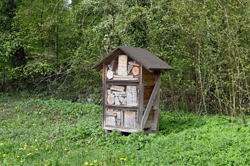 Wooden structure for bees and insects in an outdoor area. No people.