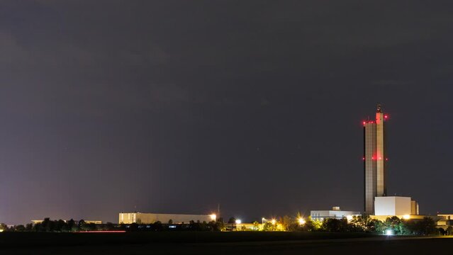 Silo tower at cloudy night with light trails time lapse