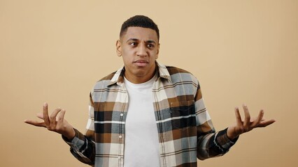Ignorance concept. Studio portrait of young puzzled black guy saying I don't know, thinking and rejecting