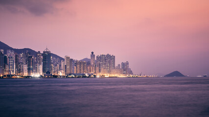 Urban skyline with illuminated skyscrapers at dusk. Hong Kong cityscape..