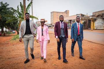 A group of young African guys (one female and three boys) walk the streets of the city, concept of...