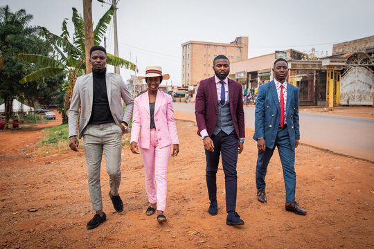 A group of young African guys (one female and three boys) walk the streets of the city, concept of Sapologie in Africa