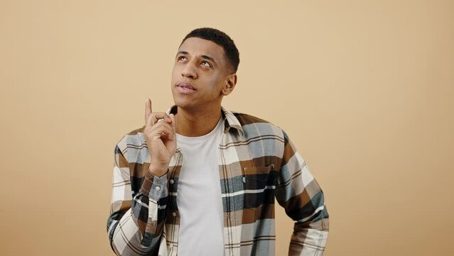 Studio portrait of young stylish pensive african american guy thinking, compering ideas and solutions