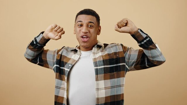 Young excited african american guy waiting and appreciating win, emotionally enjoying and shouting to camera