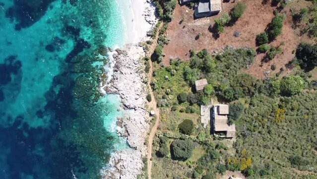 Top view of a very beautiful white sandy beach with small waves (Zingaro on the island of Sicily in Italy), sunny weather