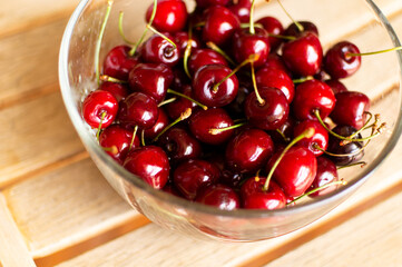 Ripe cherries in a bowl on a chair. The concept of summer, relaxation and healthy eating. Front view.