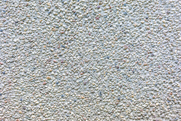 The surface is covered with a large number of very small colored stones, as a background, texture, pattern.