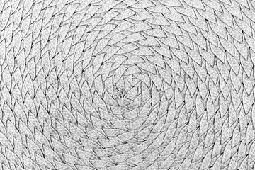 The surface is formed by spirally intertwined strips of straw as a background, texture, pattern. Black and white photo.