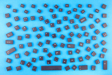 Chaotically scattered black buttons on a computer keyboard as a background, texture, pattern.