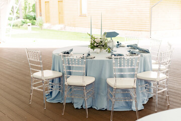 Floral table decoration for holidays and weddings. Wedding travelers, tourists. A set table for a celebration, event, party or wedding in an outdoor restaurant. Soft selective focus.