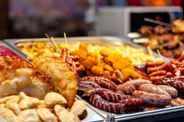 Showcase with prepared food: various fried sausages, barbecues, dumplings, chebureks.